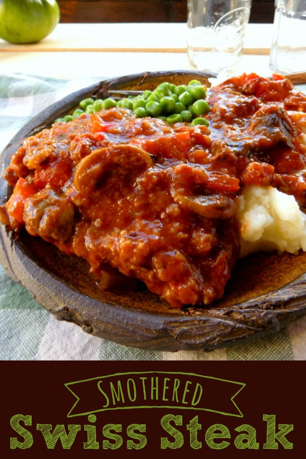 Smothered Swiss Steak with peas and mashed potatoes on a wooden plate 