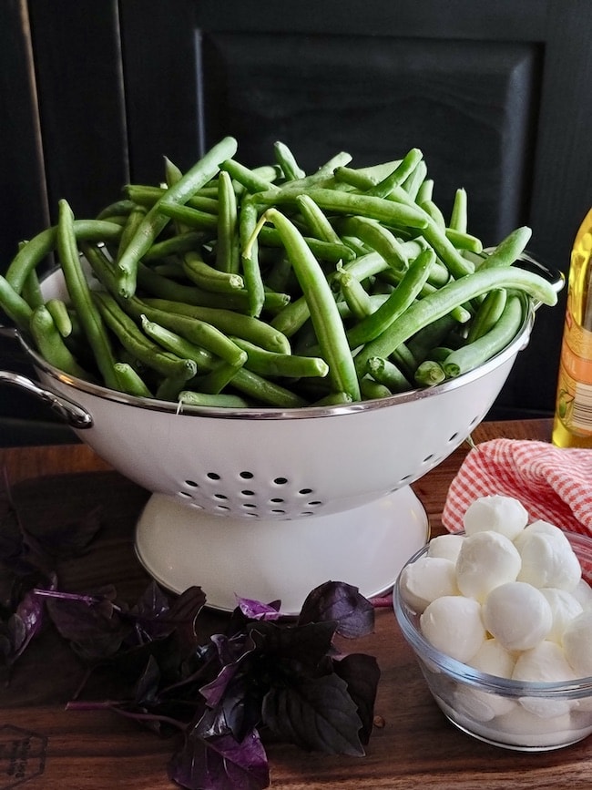 Green Beans in a colander with basil and fresh mozzarella