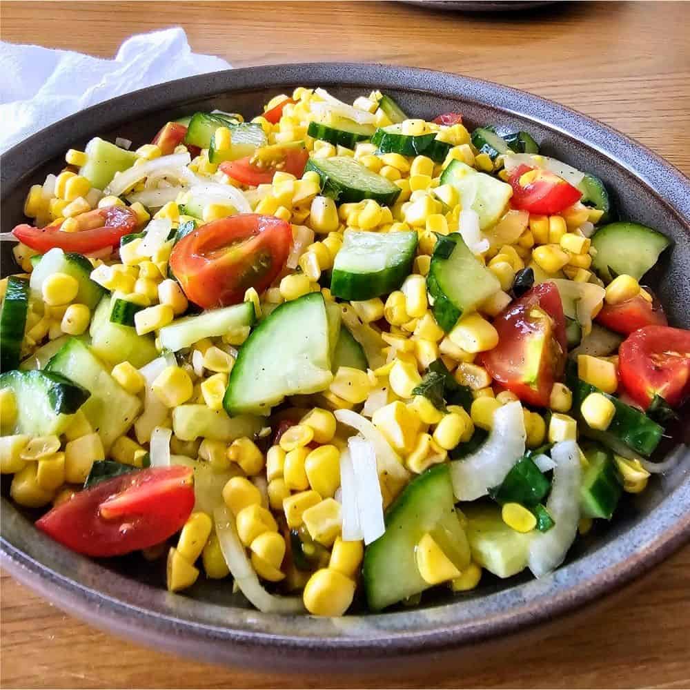 Bowl of Corn and Cucumber Salad with Cherry Tomatoes and Basil