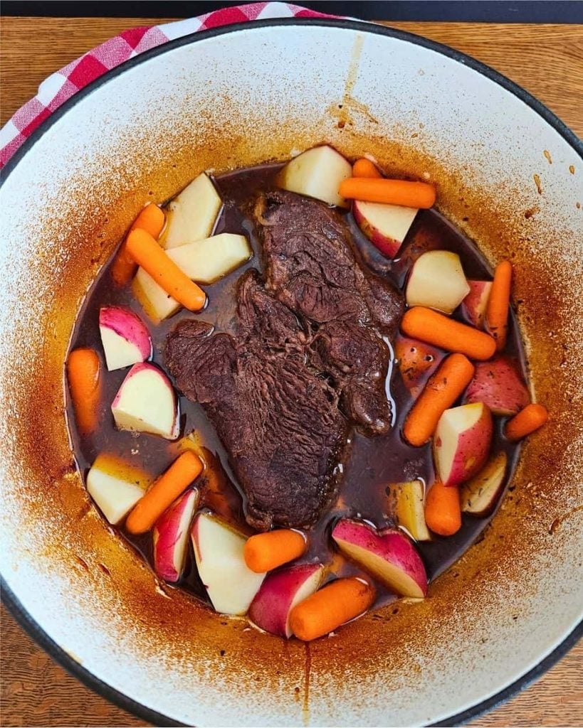 Dutch oven with Old-Fashioned Oven Pot Roasst with Carrots and Potatoes. 